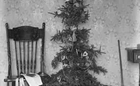 Vintage sparse Christmas tree beside wooden chair