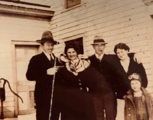 Vintage family portrait outside snowy wooden house