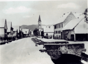 Snow-covered village street with church steeple