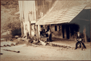 Vintage sawmill workers outside rustic wooden building