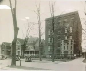 Historic brick apartment building with vintage cars