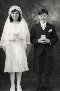 Vintage black-and-white portrait: veiled girl, boy holding books