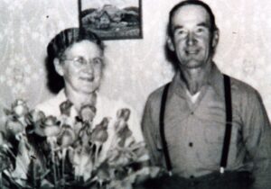 Elderly couple smiling beside bouquet