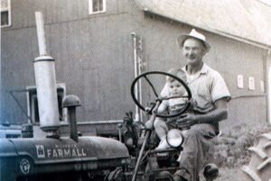 Man and baby on vintage Farmall tractor