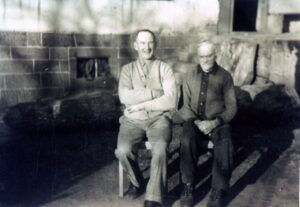 Black-and-white photo of two men seated outdoors