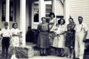 Black-and-white family portrait on front porch
