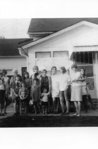 Vintage black-and-white group photo in front of house