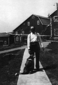 Vintage man with dog on farmhouse walkway