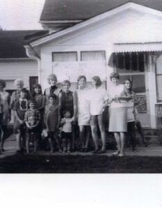 Black-and-white group photo outside a house