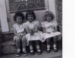 Three vintage girls on stone doorstep