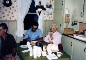 Vintage kitchen scene: three people with cake