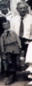 Vintage group photo of child standing beside man