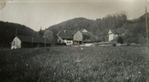 Old rural farmhouses with grassy meadow and hills